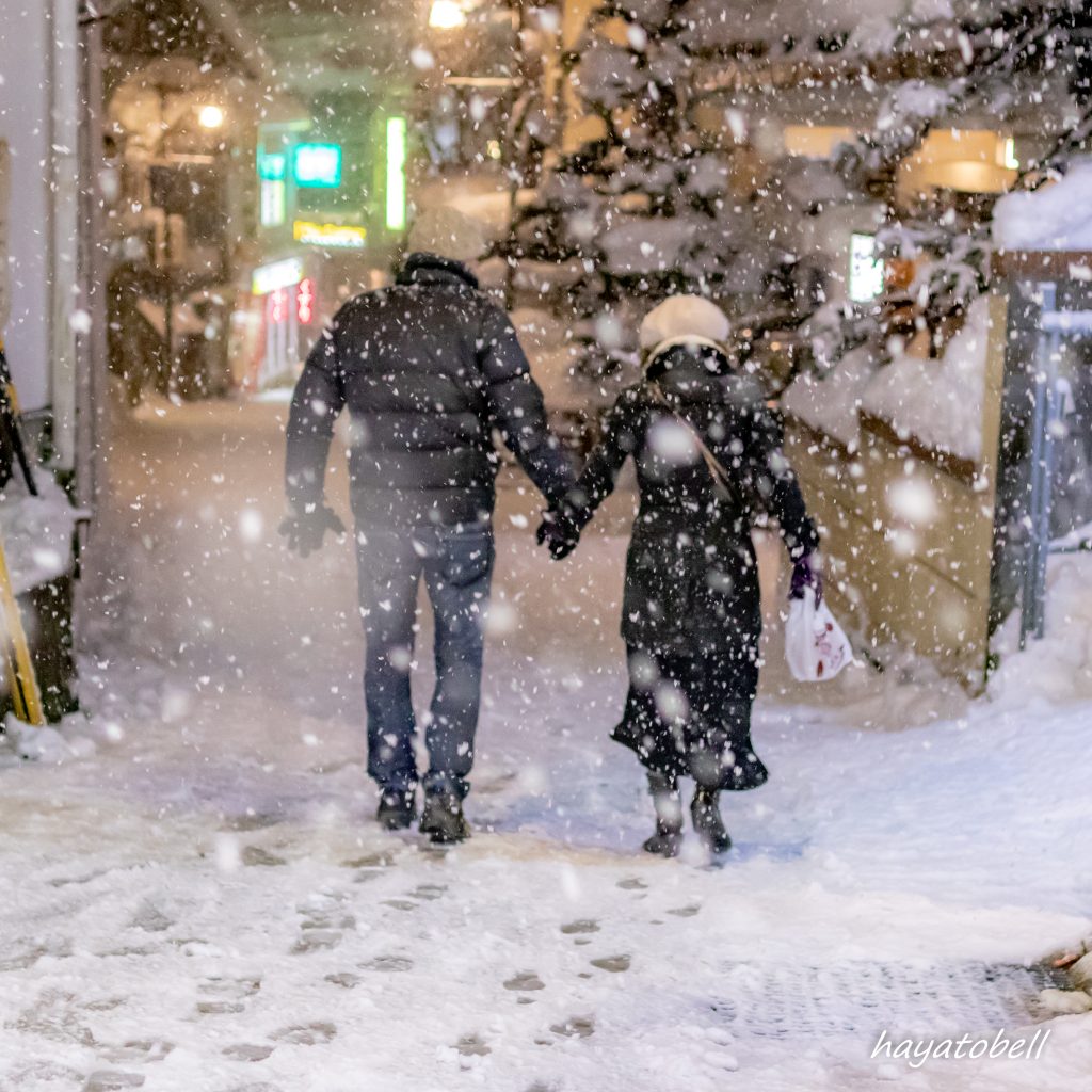 雪の中を歩くカップル（野沢温泉）